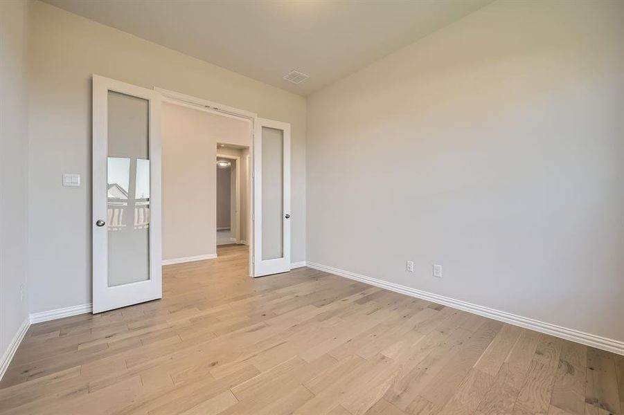 Empty room featuring french doors and light hardwood / wood-style floors