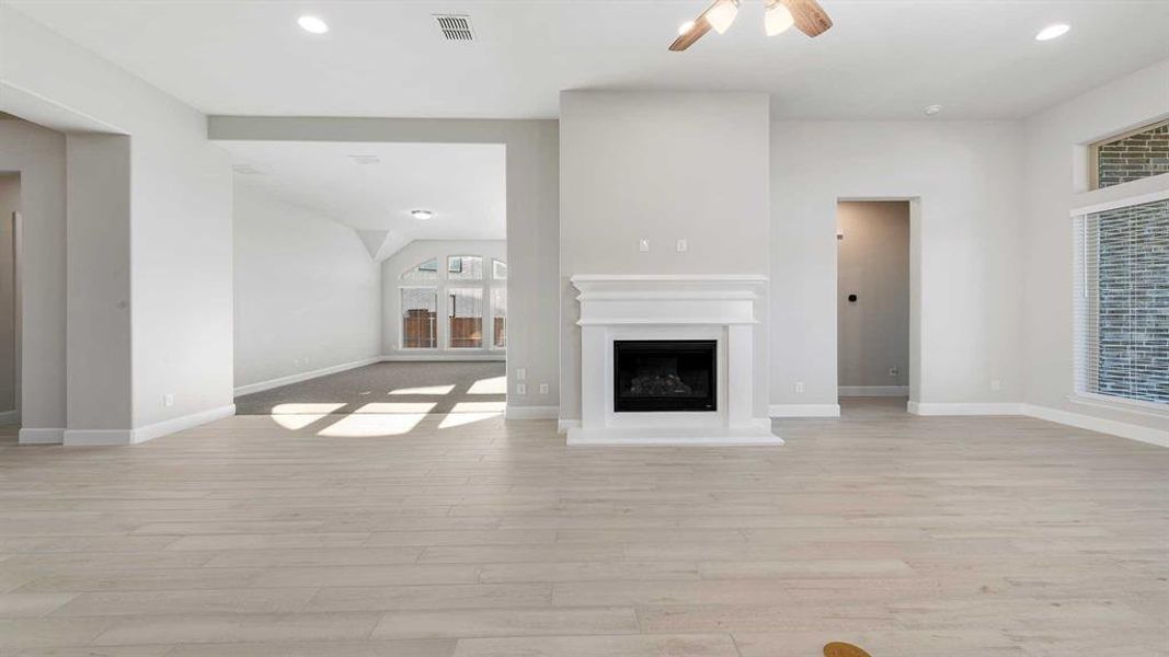 Unfurnished living room featuring ceiling fan and light hardwood / wood-style flooring