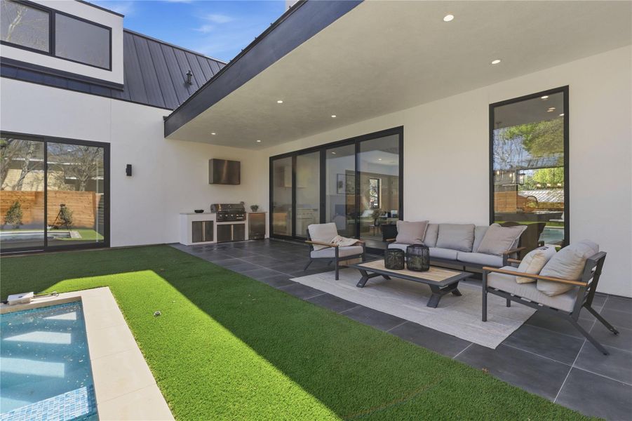 An inviting outdoor area with a built-in grill and covered seating. An inviting outdoor area with a built-in grill and covered seating.