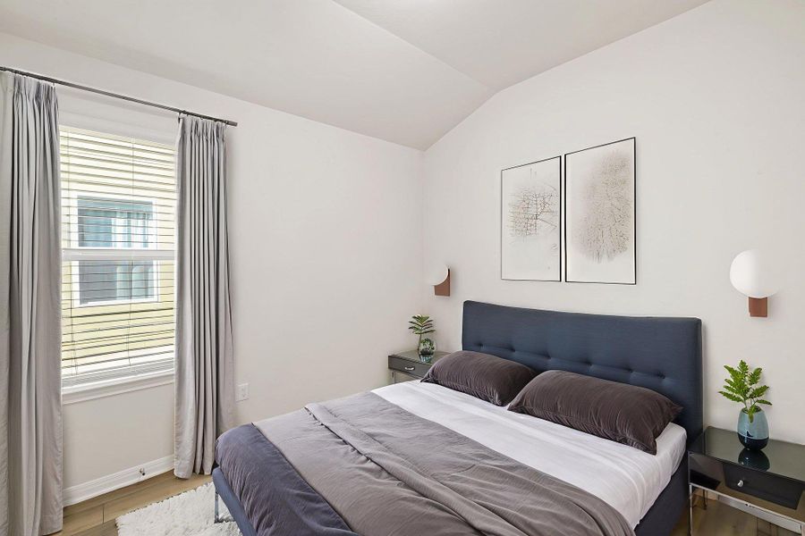 Bedroom featuring vaulted ceiling and wood finished floors Bedroom featuring vaulted ceiling and wood finished floors