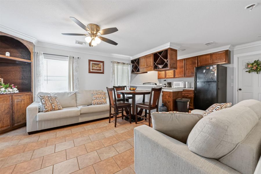 Second-level living area featuring open-concept layout, tile flooring, and adjacent kitchen.