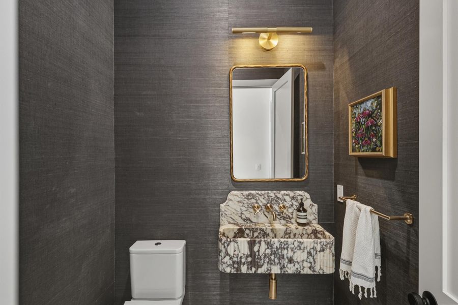 Powder room with custom viola marble sink, seagrass wallpaper, marlbe floors & Brizo plumbing fixtures