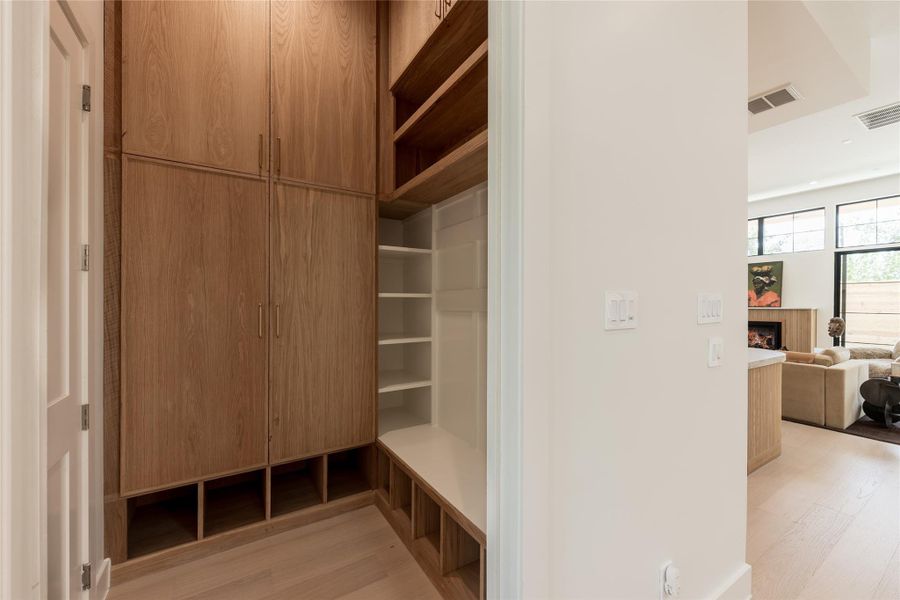 The mudroom brings everyday function into the design, with custom built in cabinetry, open shelving and a dedicated bench positioned just off the garage for an organized arrival home. The mudroom brings everyday function into the design, with custom built in cabinetry, open shelving and a dedicated bench positioned just off the garage for an organized arrival home.
