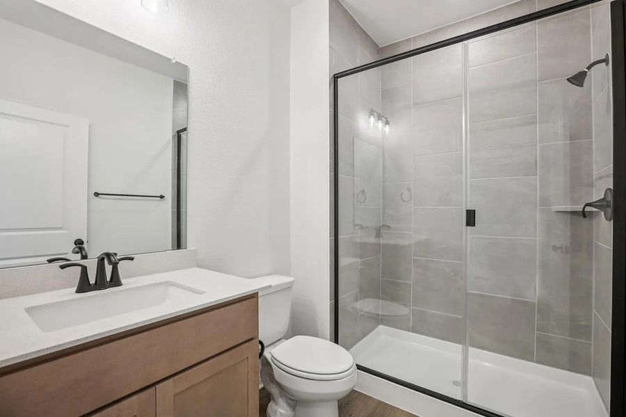 A well-appointed bathroom features a spacious glass-enclosed shower and a sleek vanity with modern fixtures. A well-appointed bathroom features a spacious glass-enclosed shower and a sleek vanity with modern fixtures.