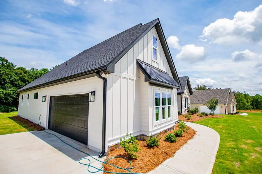 Front exterior of a new home in WOODMONT RESERVE, Roopville, GA, highlighting curb appeal (Image 31).
