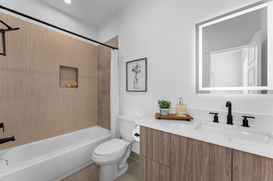 This ensuite bathroom, located in the third-floor secondary bedroom, showcases sleek modern finishes with stylish tile, a contemporary vanity topped with quartz countertops, and elegant lighting that brightens the space, creating a private retreat that is both functional and sophisticated.