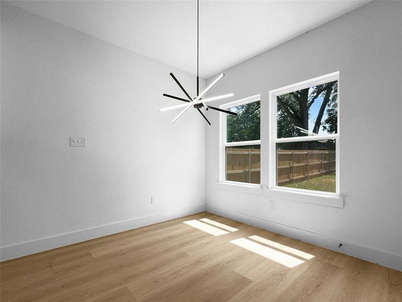Unfurnished dining area with baseboards and light wood-type flooring