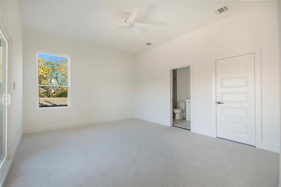 Unfurnished bedroom featuring carpet, ensuite bath, and a ceiling fan Unfurnished bedroom featuring carpet, ensuite bath, and a ceiling fan