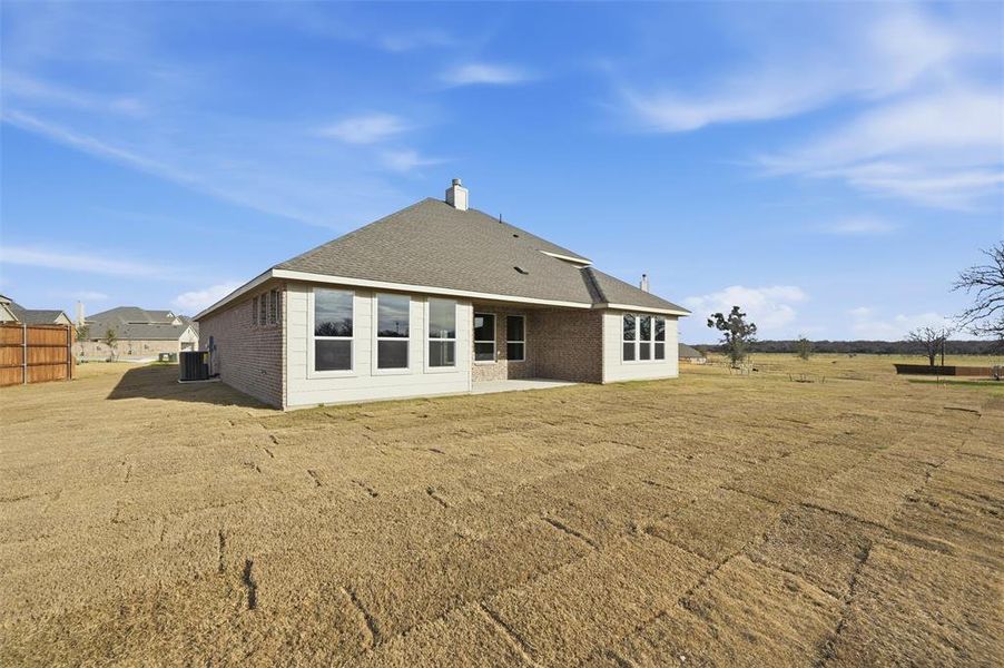 Back of house with a patio area, brick siding, and a yard