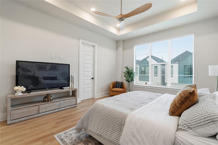 Designed to feel open and inviting, the primary bedroom is filled with natural light from oversized windows, while tray ceilings add dimension above. His and her closets complete the space with thoughtful functionality. Designed to feel open and inviting, the primary bedroom is filled with natural light from oversized windows, while tray ceilings add dimension above. His and her closets complete the space with thoughtful functionality.
