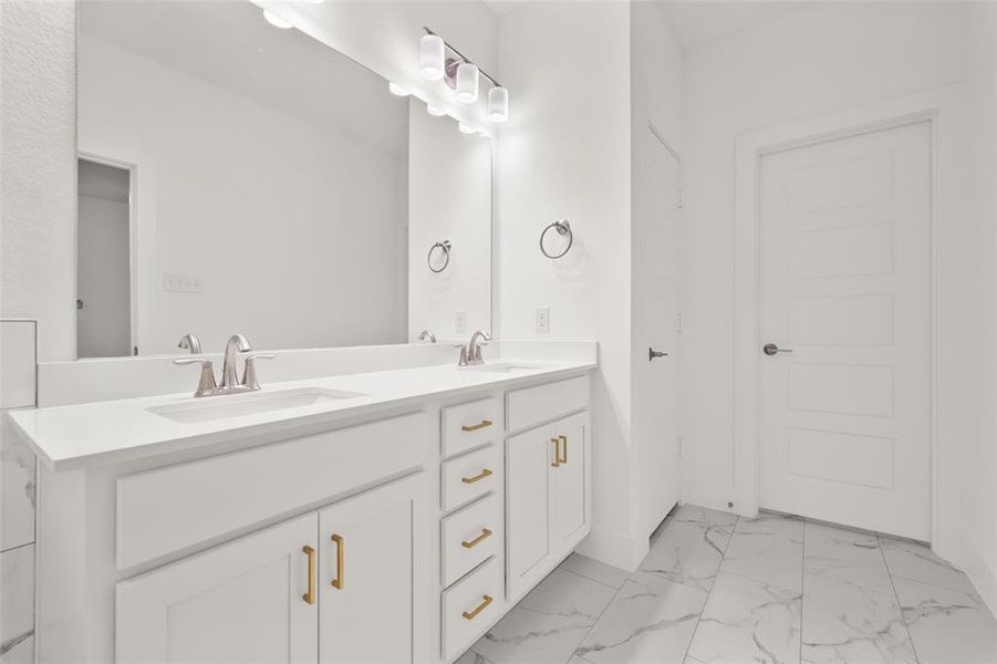 Primary bathroom with two sinks, tile floors, and a separate shower and tub.