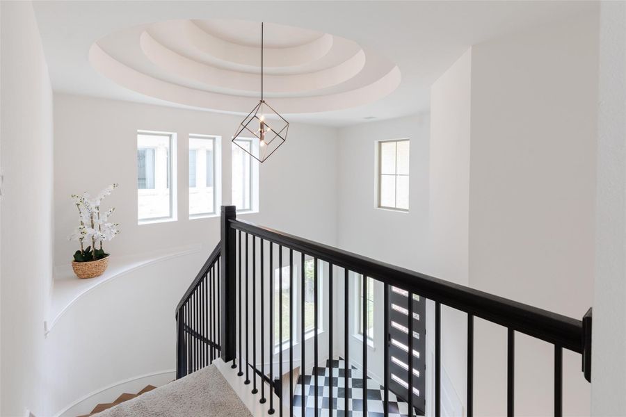Modern stairway with a sleek black railing and a statement light fixture