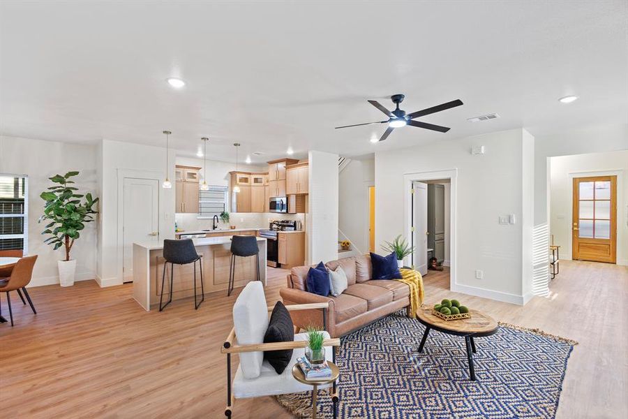 Living room with light hardwood / wood-style floors and ceiling fan