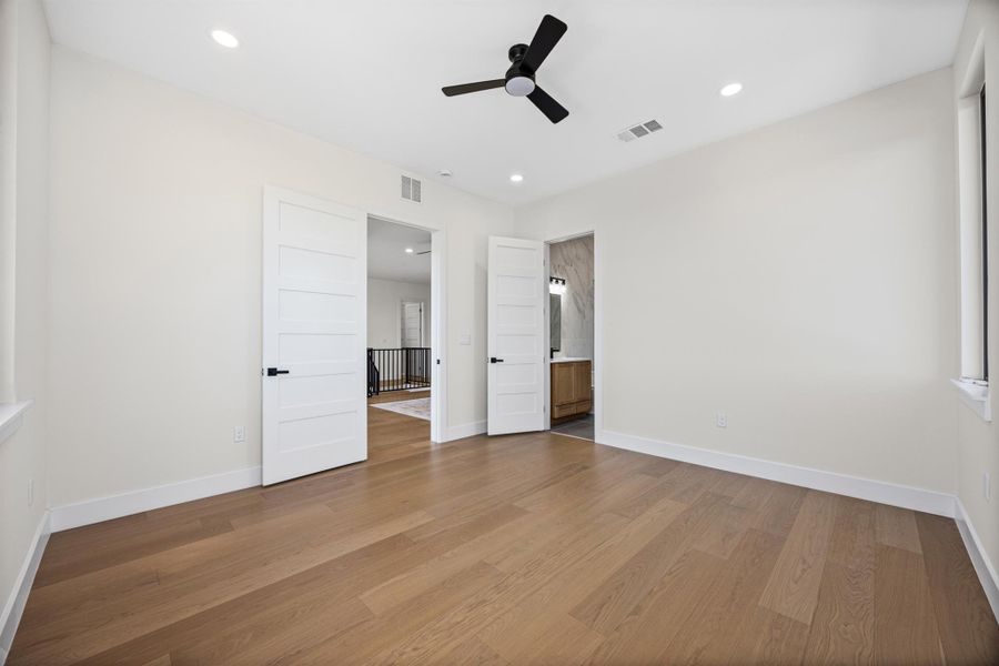 Unfurnished bedroom with recessed lighting, a ceiling fan, dark wood finished floors, and ensuite bath