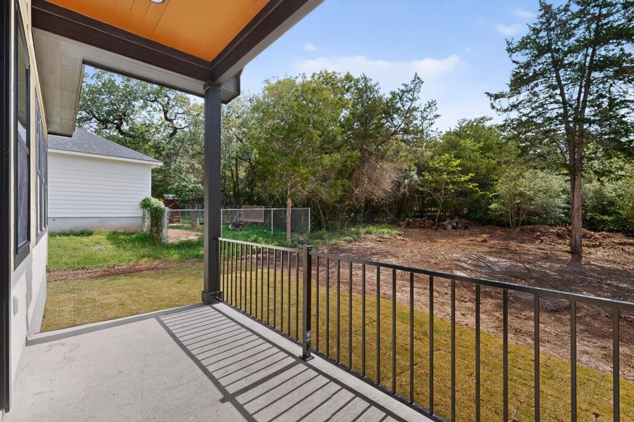 A spacious covered patio provides a serene outlook onto the undeveloped backyard, ready for your personalized landscape vision.