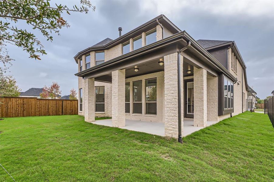 Rear view of property with a yard and a patio area