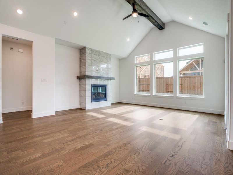 Wonderful family memories are waiting to be made in this spacious family room featuring a lovely fireplace, beautiful flooring and stunning center ceiling beam!