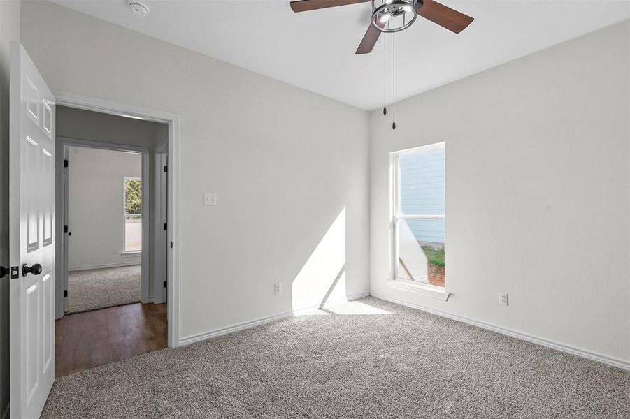 Unfurnished room featuring a healthy amount of sunlight, wood-type flooring, and ceiling fan