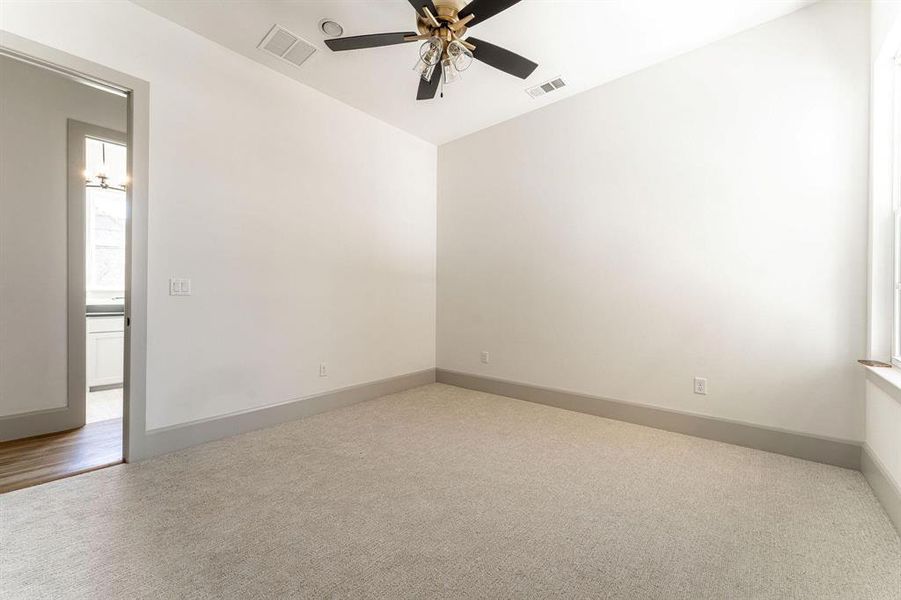 Empty room featuring carpet and a ceiling fan