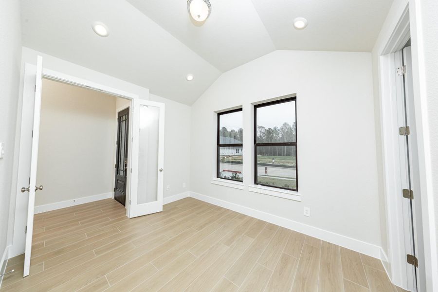 Tucked peacefully in the front of the home is this study, which features large windows, tile flooring, French doors, and neutral toned walls.