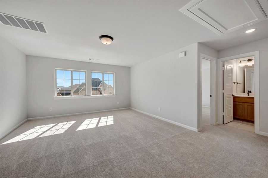 Unfurnished bedroom with light colored carpet and ensuite bathroom