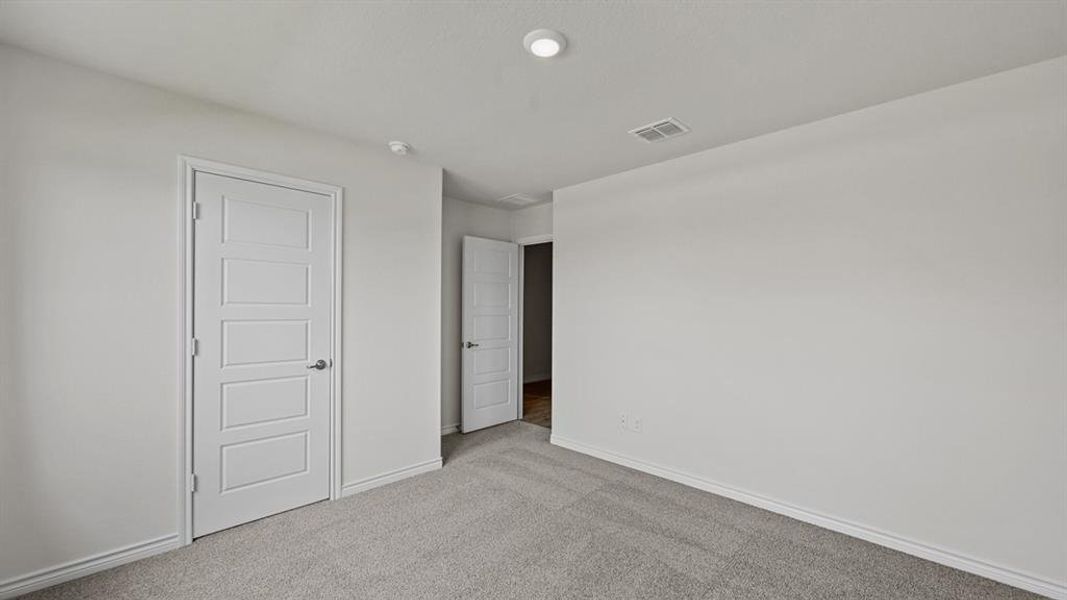 Neutral wall paint and carpeted flooring define this interior space, featuring a contemporary five-panel interior door with a chrome handle Neutral wall paint and carpeted flooring define this interior space, featuring a contemporary five-panel interior door with a chrome handle