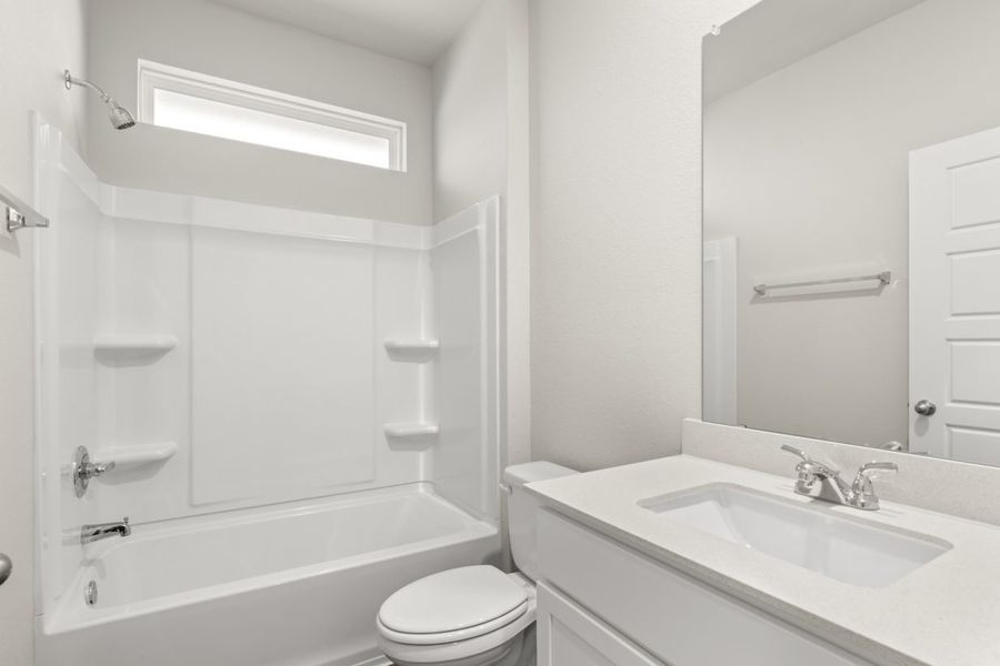 Image of a bathroom with a white vanity, a white shower ILO tub with a window above and a mirror