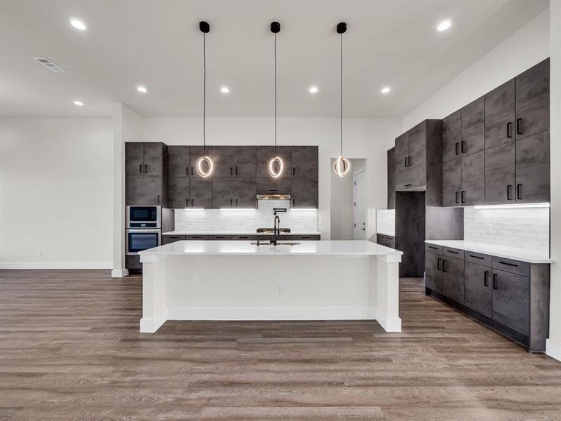 Kitchen with light hardwood / wood-style floors and pendant lighting