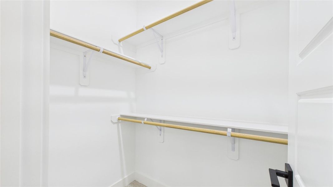 This spacious walk-in primary closet offers ample storage and organization, designed for both functionality and style. With generous shelving, hanging space, and well-placed lighting, it creates an elegant and practical wardrobe area. Thoughtfully designed to maximize convenience, this closet enhances the home's luxury and everyday comfort. This spacious walk-in primary closet offers ample storage and organization, designed for both functionality and style. With generous shelving, hanging space, and well-placed lighting, it creates an elegant and practical wardrobe area. Thoughtfully designed to maximize convenience, this closet enhances the home's luxury and everyday comfort.