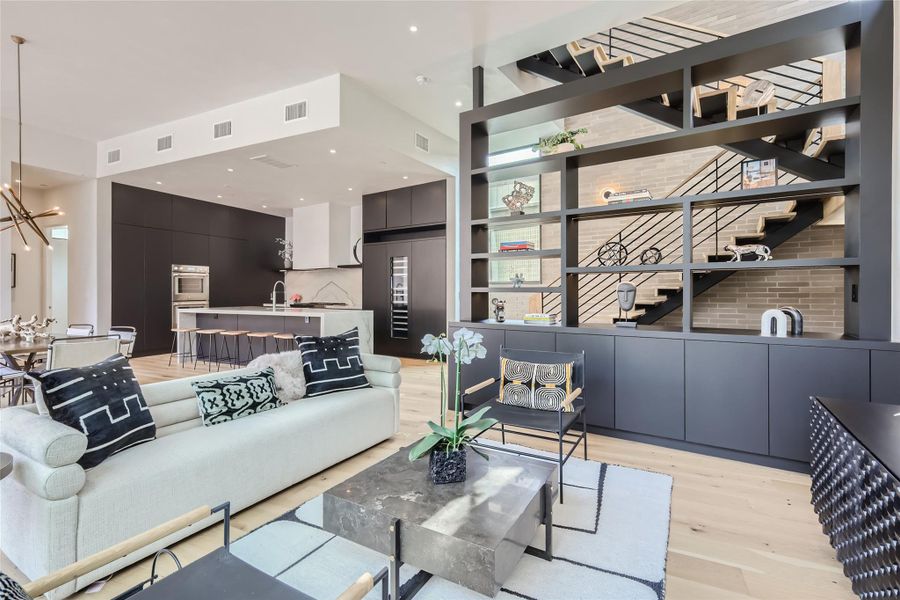 An open-concept interior unites kitchen, dining, and living areas under recessed lighting, showcasing a sleek, modern design. An open-concept interior unites kitchen, dining, and living areas under recessed lighting, showcasing a sleek, modern design.