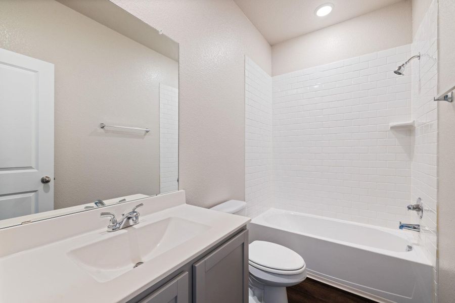 Bathroom featuring shower / bathtub combination, vanity, and dark wood finished floors