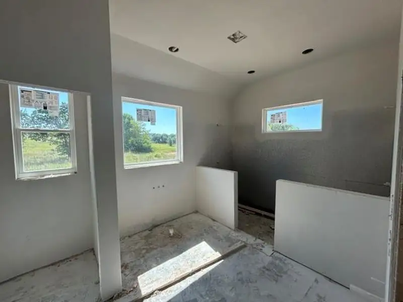 Room featuring three windows, a recessed ceiling light, and two half-walls defining a space Room featuring three windows, a recessed ceiling light, and two half-walls defining a space