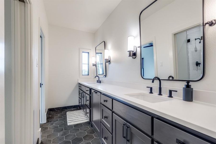 Full bath featuring double vanity, tile patterned floors, and a shower Full bath featuring double vanity, tile patterned floors, and a shower
