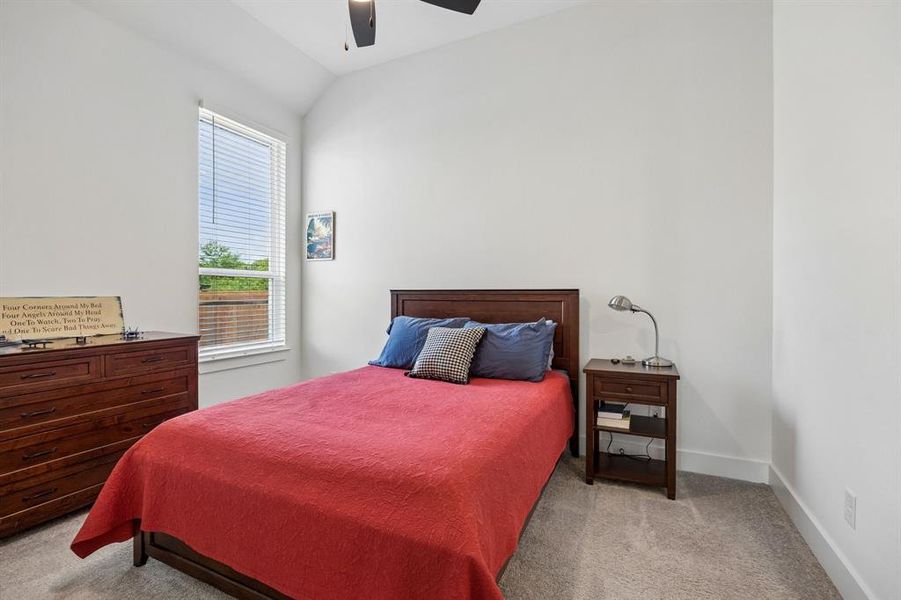 High vaulted ceiling bedroom featuring a ceiling fan, light gray carpet, and a multi-pane window with white blinds High vaulted ceiling bedroom featuring a ceiling fan, light gray carpet, and a multi-pane window with white blinds