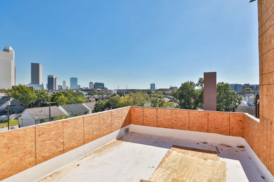This photo showcases a partially constructed rooftop area with a view of a city skyline and nearby residential neighborhood. The open space offers potential for development and picturesque urban scenery. This photo showcases a partially constructed rooftop area with a view of a city skyline and nearby residential neighborhood. The open space offers potential for development and picturesque urban scenery.