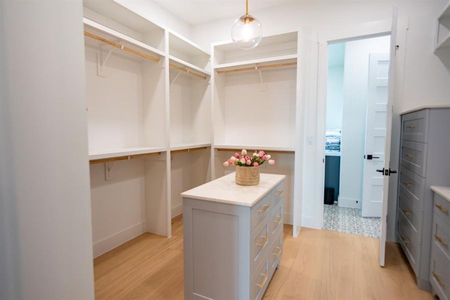 Walk in closet featuring light wood-style floors Walk in closet featuring light wood-style floors