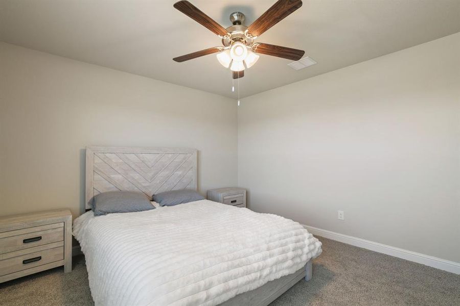 Bedroom featuring dark carpet and a ceiling fan Bedroom featuring dark carpet and a ceiling fan