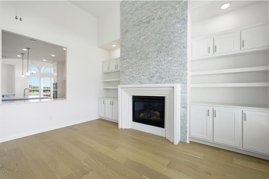 Living area featuring a floor-to-ceiling stacked stone fireplace surround with a classic white mantel