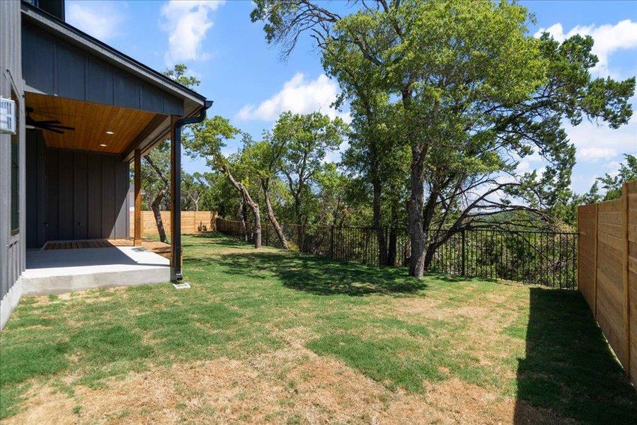Fenced backyard with a patio and a ceiling fan