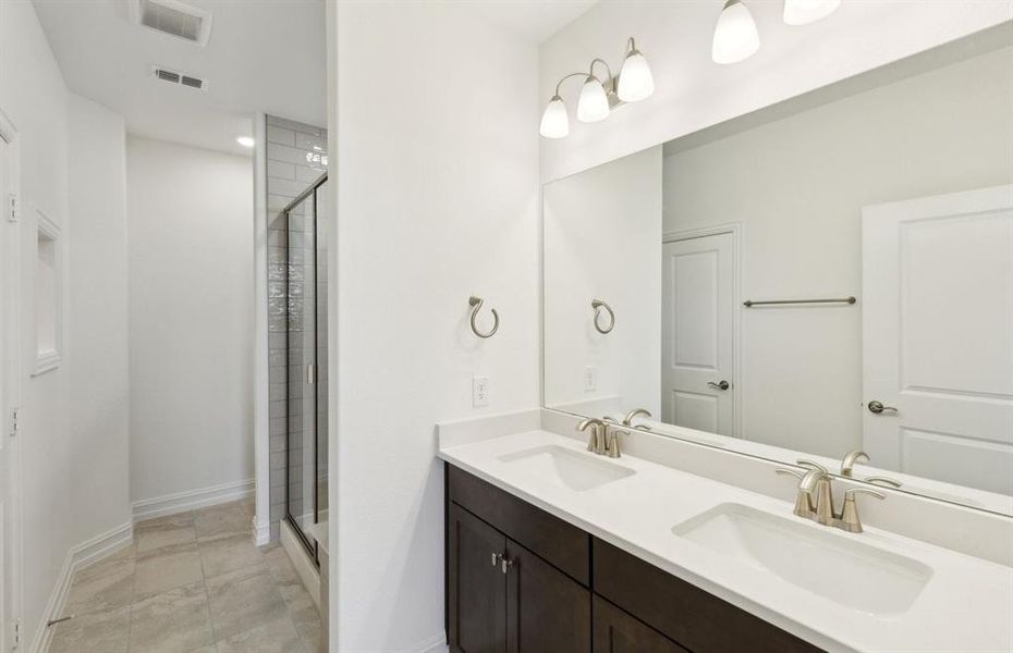 Elegant owner's bathroom with dual vanity *real home pictured