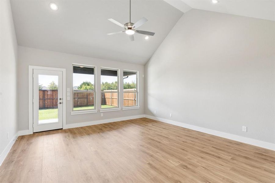 Empty room featuring high vaulted ceiling, light wood finished floors, recessed lighting, and a ceiling fan