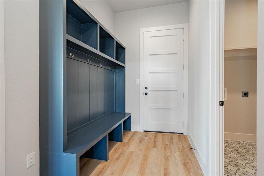 Example of builders Mudroom with wood-type flooring