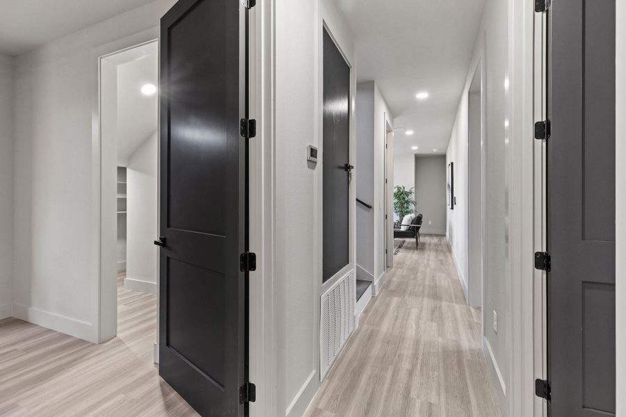 Hall with recessed lighting, visible vents, baseboards, and light wood-style floors