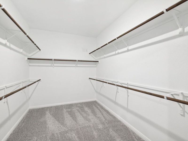 This spacious primary bedroom closet has lots of room for clothes and storage.