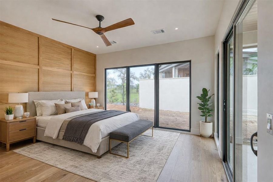 Primary suite is Virtually enhanced. The bedroom features a wall of windows, oak judges paneling, and a large closet with access to the laundry.