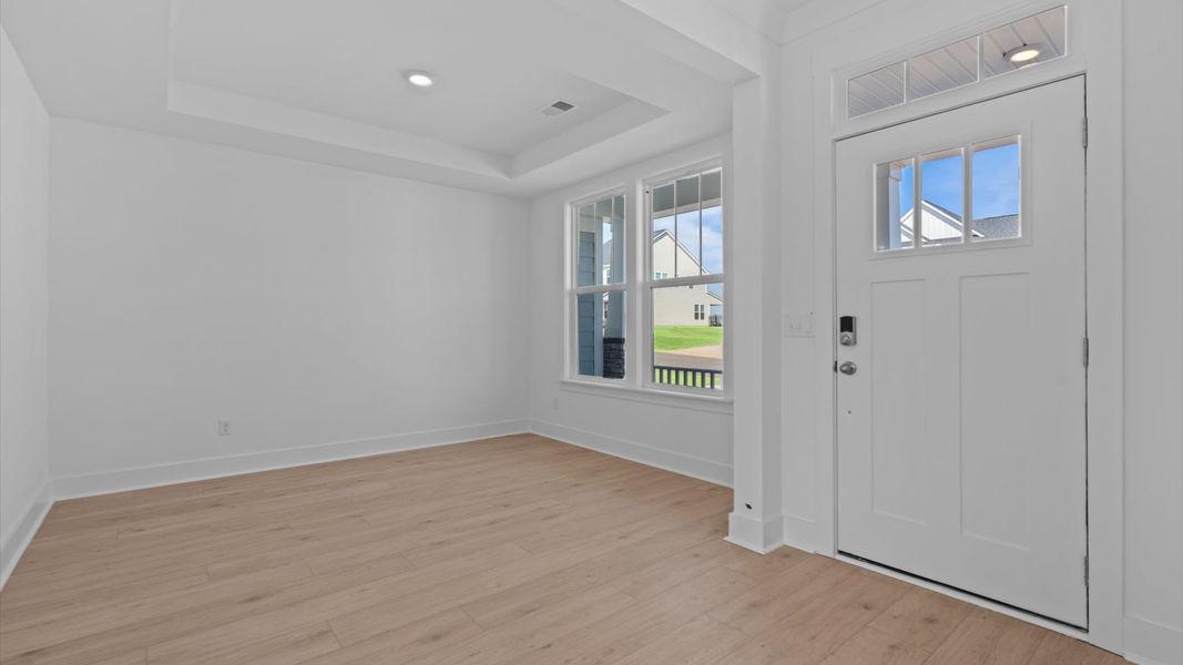 Tasteful living room with tray ceiling, modern fixtures, and a warm, inviting feel