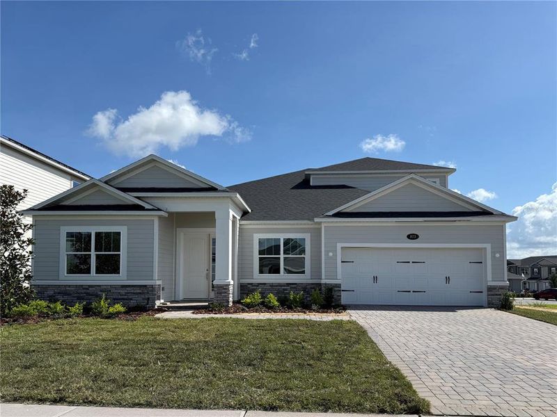 Front exterior of a new home in Emerson Pointe, Apopka, FL, highlighting curb appeal (Image 1).