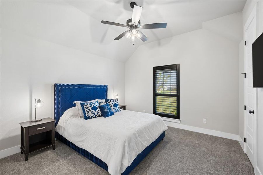 Bedroom featuring vaulted ceiling, carpet floors, and ceiling fan