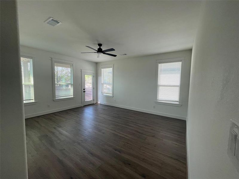 Empty room with ceiling fan and dark wood-style floors