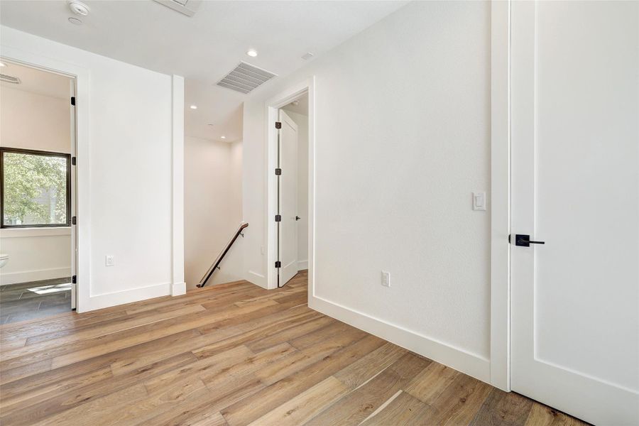 Spare room featuring wood finished floors, recessed lighting, and baseboards